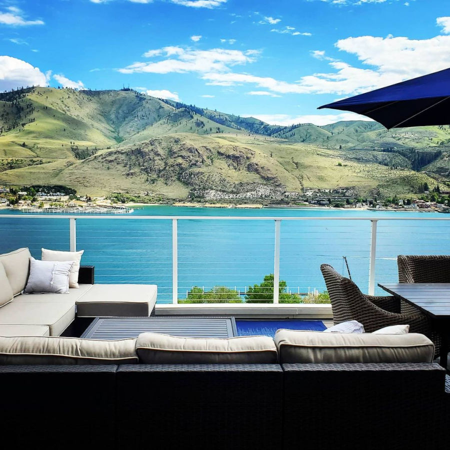 Deck lakefront view of water and hills through white cable railing to keep the view.