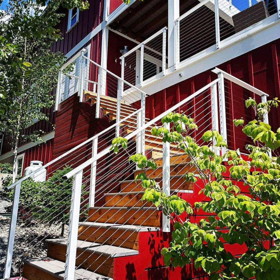 Red and white deck stairs with cable railing.