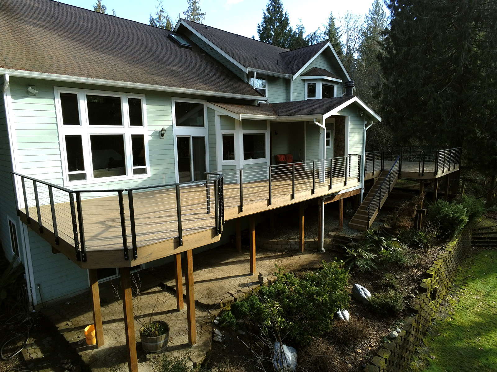 Deck with covered space, cable railing, and fencing in Maple Valley, WA