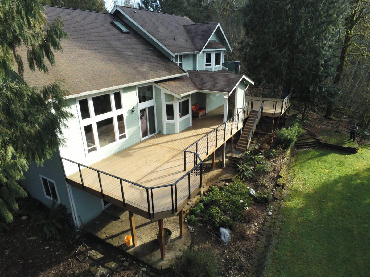 Deck w/ covered space, cable railing, and composite decking in Maple Valley, WA